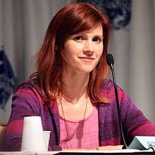 A smiling Caucasian woman with red hair.