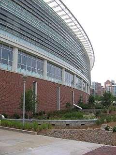 A segment of a curved building constructed from brick, metal and glass