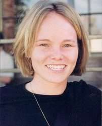 A smiling Caucasian woman with tight-cropped blond hair