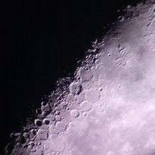 Lunar craters as captured through the backyard telescope of an amateur astronomer, partially illuminated by the sun on a waning crescent moon.