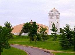 Photograph of a golden dome and a white tower.