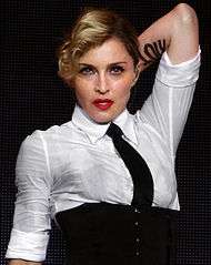 A blond woman wearing a white shirt and black necktie.