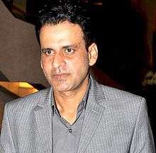 Manoj Bajpai is looking away from the camera.