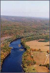 A placid river winds its way through farmland and forest.