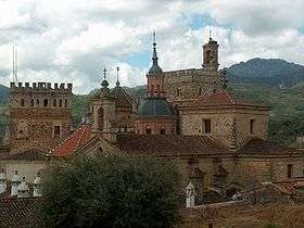 A complex of various buildings including towers made of natural stones.