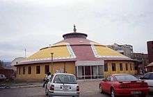 Yurt-shaped building with cars parked outside