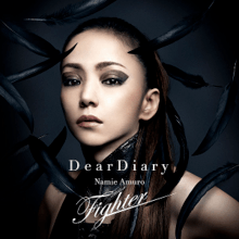 A close-up of a Japanese woman (Namie Amuro), looking towards the camera. She is wearing black eye shadow and a black outfit, in front of a dark-blue background. The song title and artist name is superimposed, whilst feathers surround her.