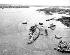 29 March 1943, Oklahoma righted to about 30 degrees. Ford Island is at right.