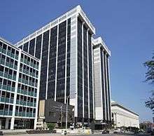 A tall, white, steel-framed building with black windows.