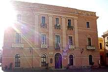 Three-story building, with flags over the entrance