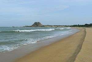 Sandy beach with a rocky outcrop in sea side