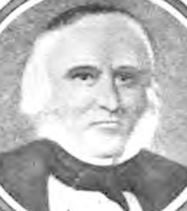 Formal portrait showing the head and shoulders of a white-haired man wearing a dark cape or coat