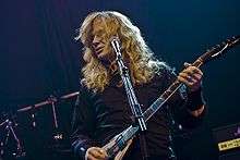 Red-haired guitarist in a black shirt in front of a microphone