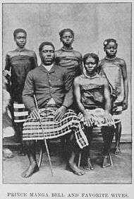 Postcard photo of Prince Manga Bell seated for portrait with four women nearby, possibly late 19th century style