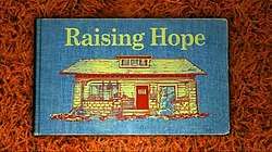 The cover of a blue storybook, with the words 'Raising Hope' written in yellow above a picture of a house.