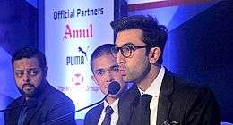 Ranbir Kapoor talking speaks while two men are looking at him