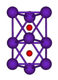 The ball-and-stick diagram shows two regular octahedra which are connected to each other by one face. All nine vertices of the structure are purple spheres representing rubidium, and at the centre of each octahedron is a small red sphere representing oxygen.