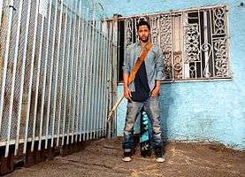 Man standing in front a blue wall