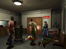 A young police officer is defending himself against a group of attacking zombies with a shotgun. The scene takes place in a small room decorated with pieces of art.