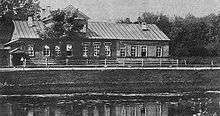 A large, low house overlooking the Tikhvinka River