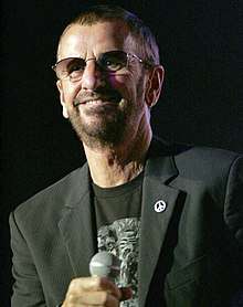 A colour photograph of Starr wearing sunglasses and a black T-shirt.