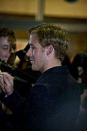 Ryan Gosling as he acknowledges the press at a red carpet premiere.