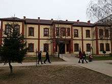 Two-story building with people walking past