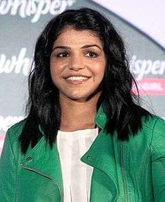 A photograph of a young woman wearing green coloured jacket.