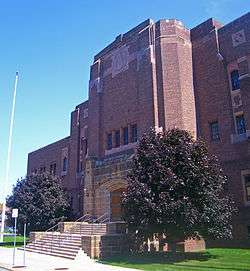 Front view of entrance and north wing of armory, a brown brick building in the Art Deco architectural style