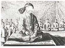 Black-and-white print of a man with small eyes and a thin mustache wearing a robe, a fur hat, and a necklace made with round beads, sitting cross-legged on a three-level platform covered with a rug. Behind him and much smaller are eight men (four on each side) sitting in the same position wearing robes and round caps, as well as four standing men with similar garb (on the left).