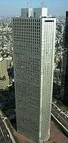 Aerial view of a gray, triangular, window-dotted high-rise