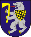 A coat of arms depicting an angry, grey bear with yellow claws and a long, red tongue gripping a yellow axe in its paws all on a blue background