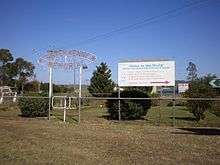 Landscaped Sister Kenny memorial, with signs and turnstile