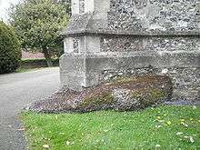 detail of a stone column resting on a large chunk of puddingstone