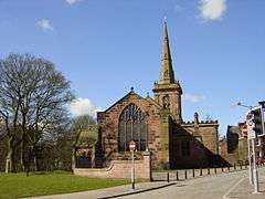 A church seen from the east with a west tower surmounted by a recessed spire