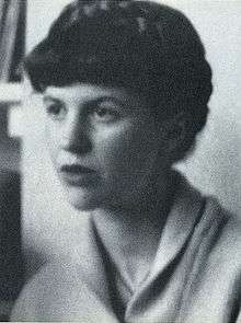 A black-and-white photo of a woman with her hair up, looking aside from the camera