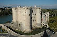 Strongly built medieval castle beside a river.