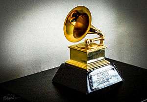 A gold gramophone trophy with a plaque set on a table