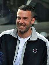 Ben Affleck, wearing a tracksuit top, smiles