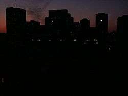 City skyline at dusk with only a very few office building windows lit