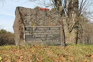 A stone marker with a metal plaque commemorating the Battle of Torrence's Tavern