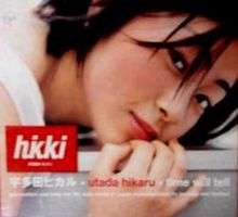 A close-up shot of a Japanese–American woman (Utada Hikaru) laying on a flat white surface.