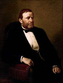 A bearded man in a black suit.