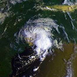 Satellite image of a tropical storm at crossing the Texas coastline. The storm is in the shape of the number "9" with bulging clouds near the bottom. Southeast Texas, northeast Mexico and southwestern Louisiana are visible in the image.