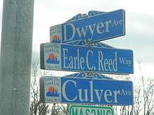 Three street signs on a pole