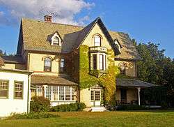 View of front of house main block in late-afternoon sunlight.