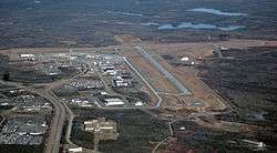 An aerial photo of an airport surrounded by forest.